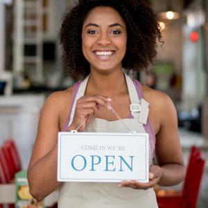 Shop owner holding sign in South Salt Lake