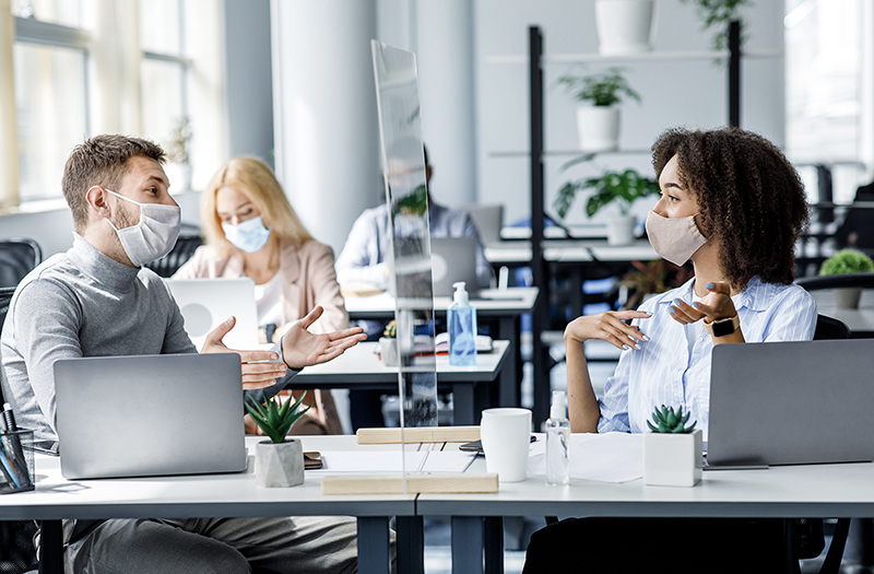 Employees interacting safely in office