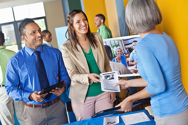 Business team handing brochure to prospective employee at job fair