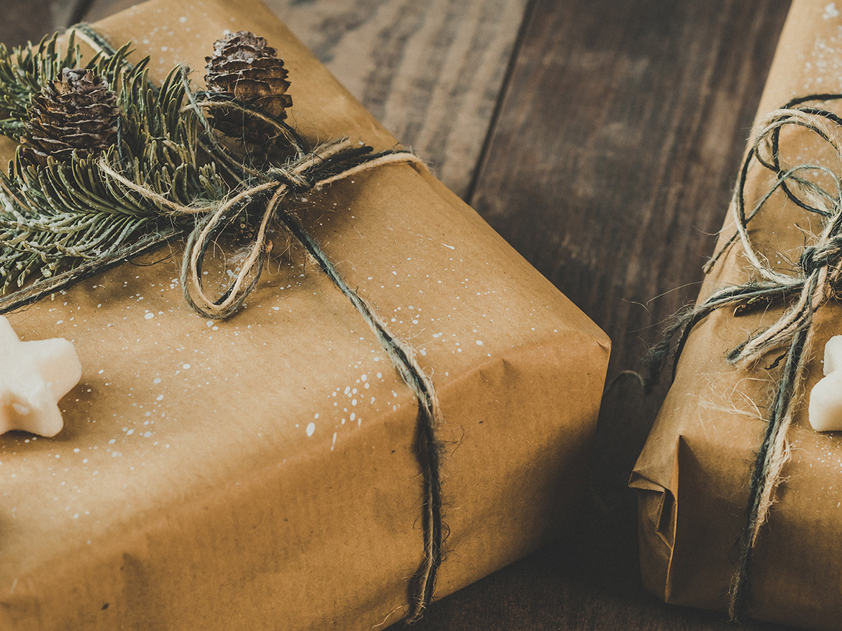 Images of beautifully wrapped presents covered in brown paper with Christmas tree branches tied to the top