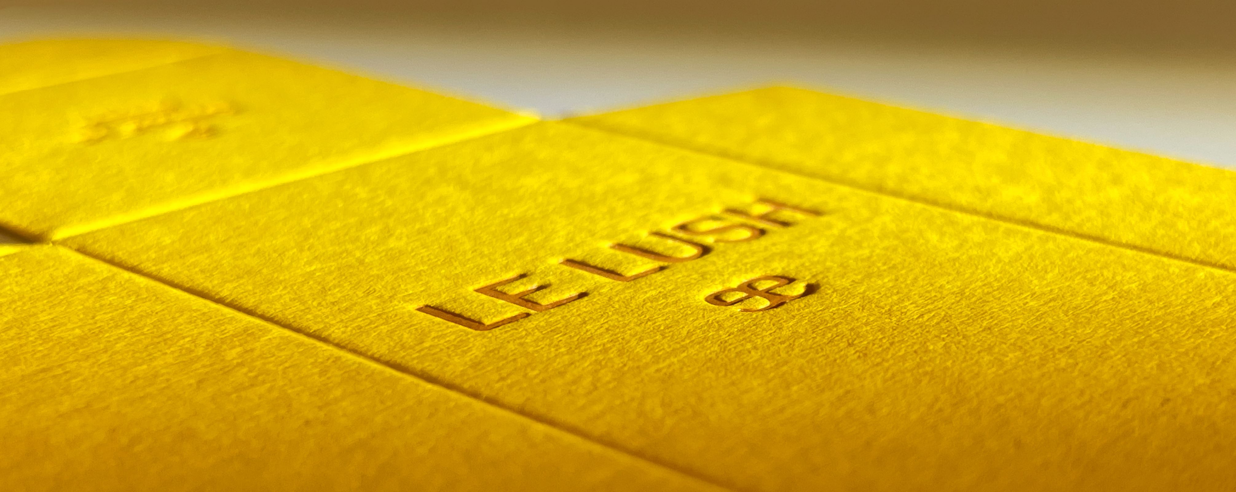 A close up of a yellow product package with a dark yellow letterpress design.
