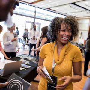 A woman at a trade show booth talking with others