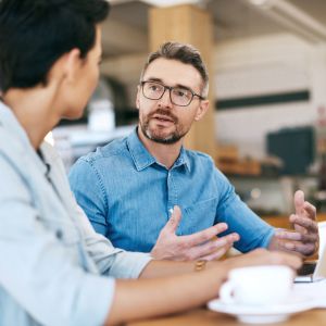 A business owner speaking with a coworker in an office