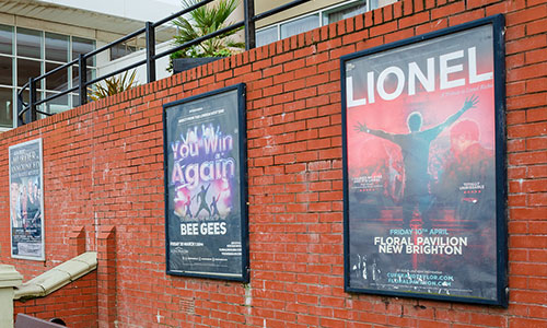 Music festival posters hung on a brick wall