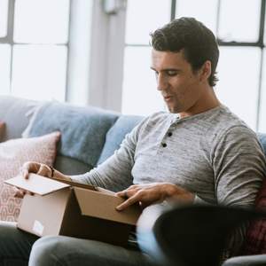 A person opening a package on their couch