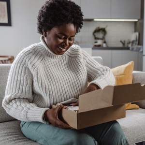 A woman opening a package from her new employer