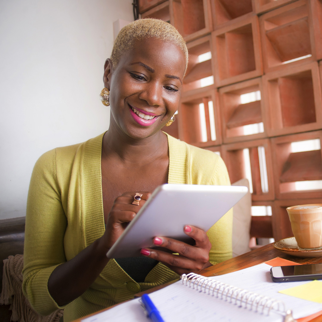 A smiling business owner looking at her tablet