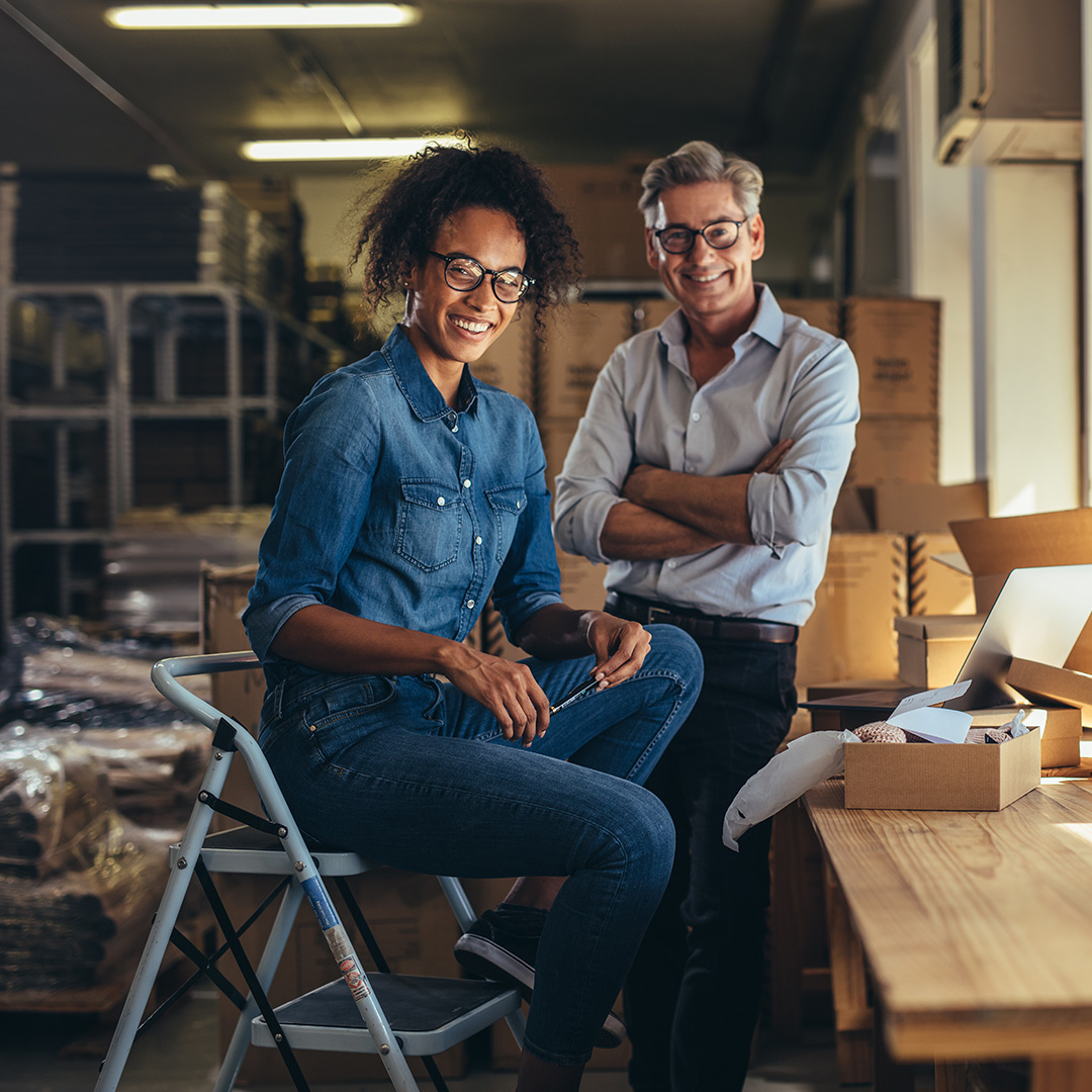 Two happy business owners in their warehouse 