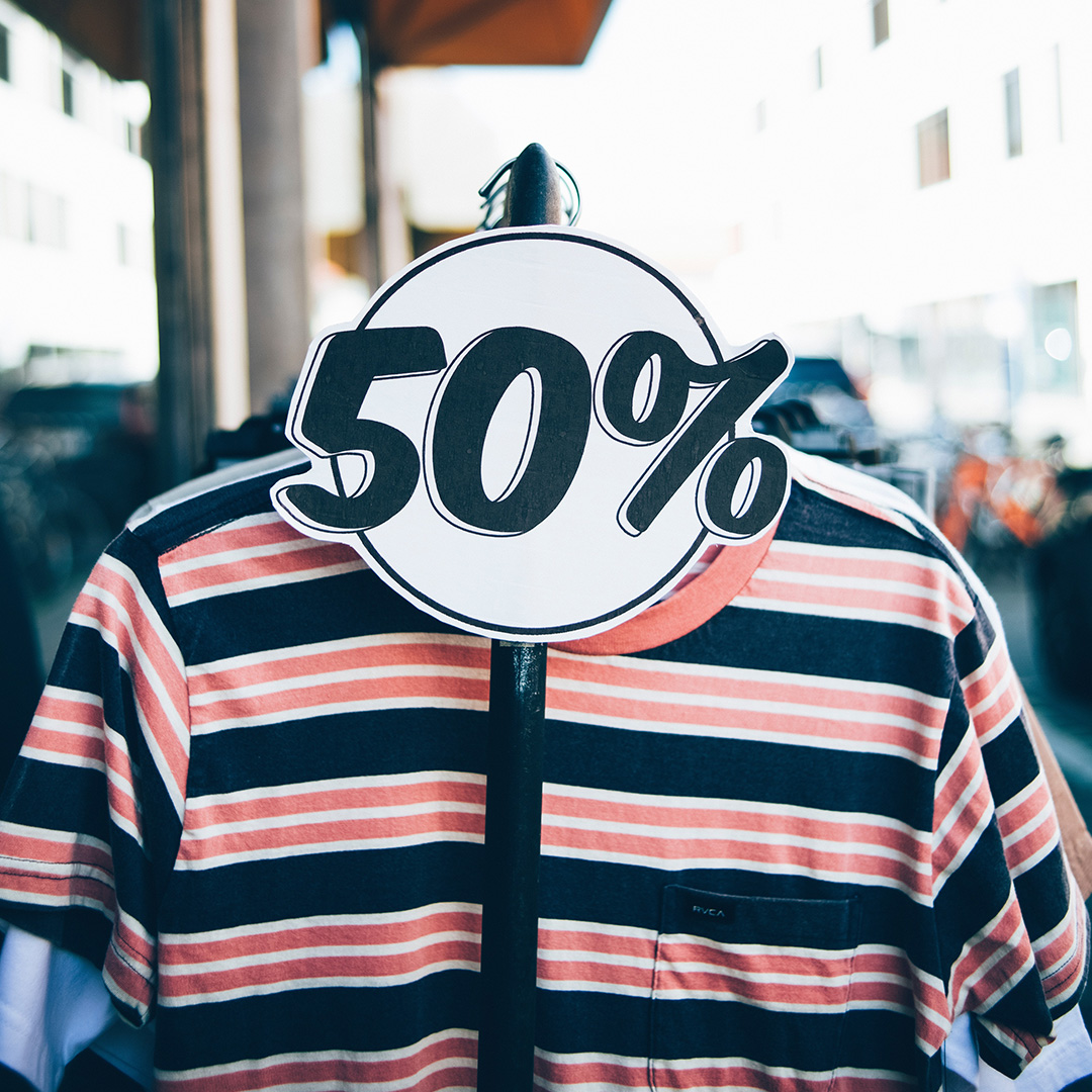 A 50% off sale sign on a clothing rack