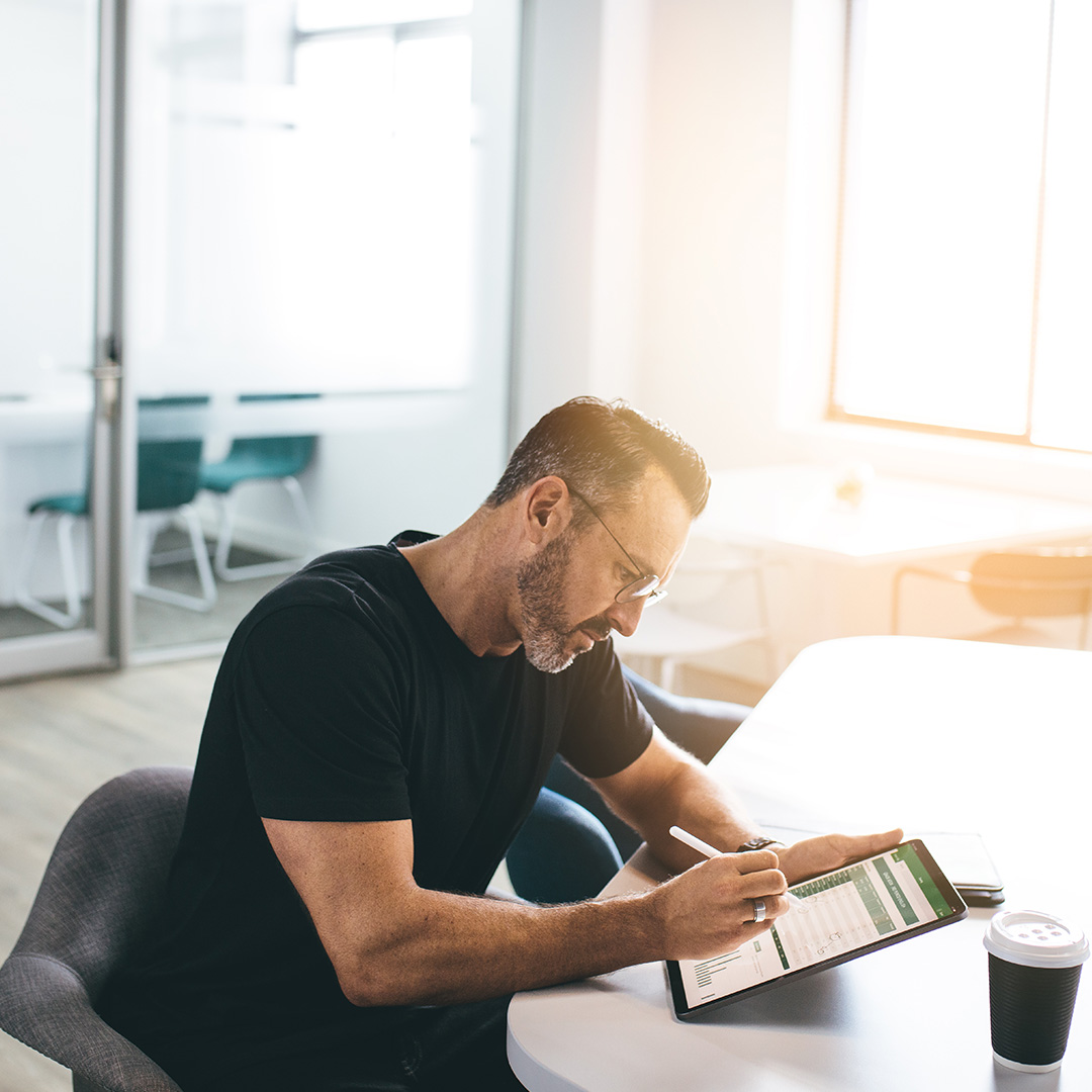 A business owner looking at his tablet in his office