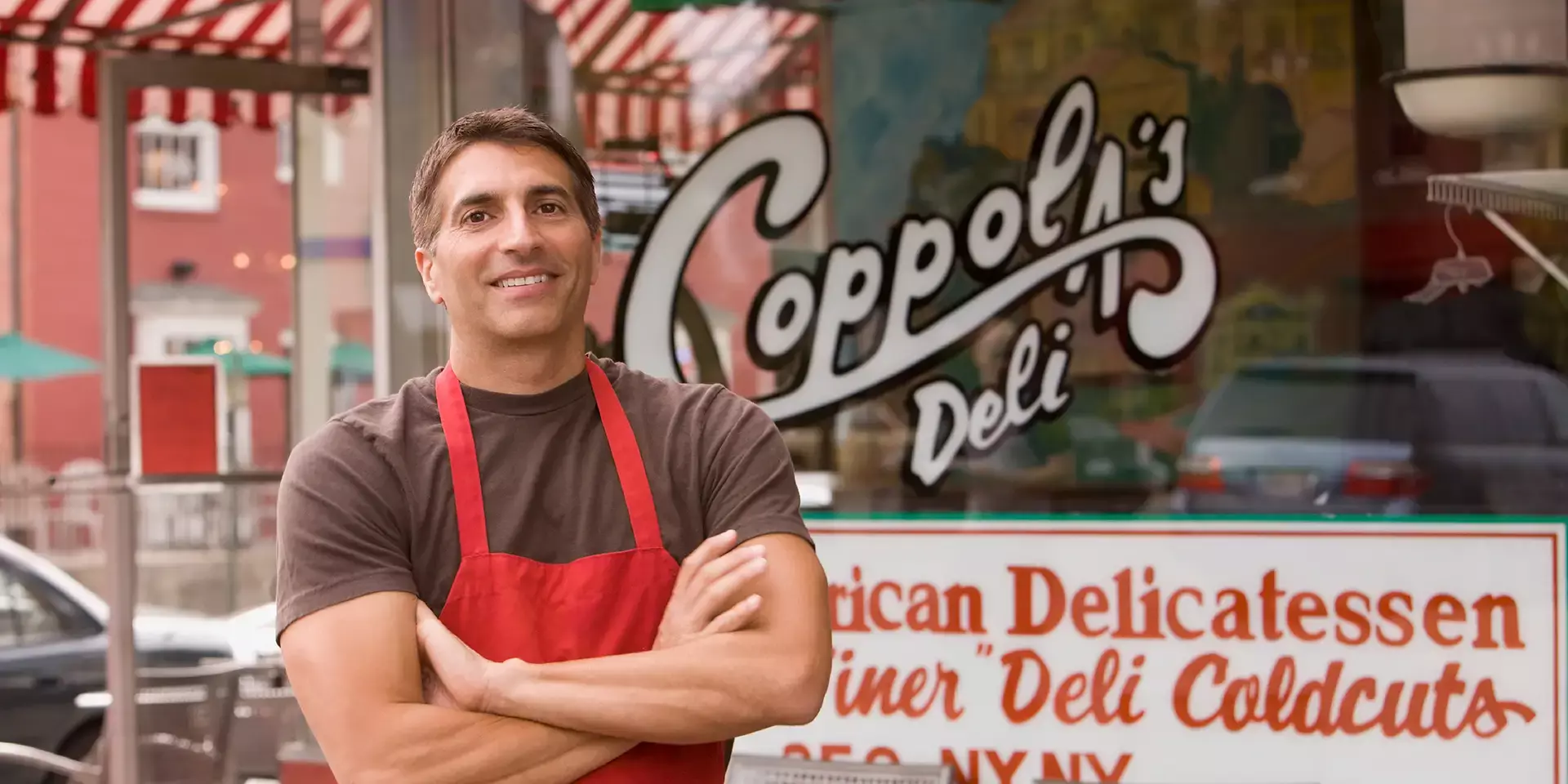 Business owner standing in front of his deli