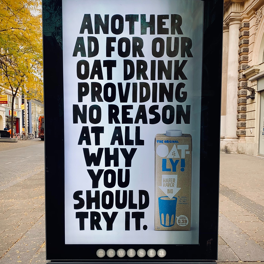 A sign board in the middle of the sidewalk advertising oat milk