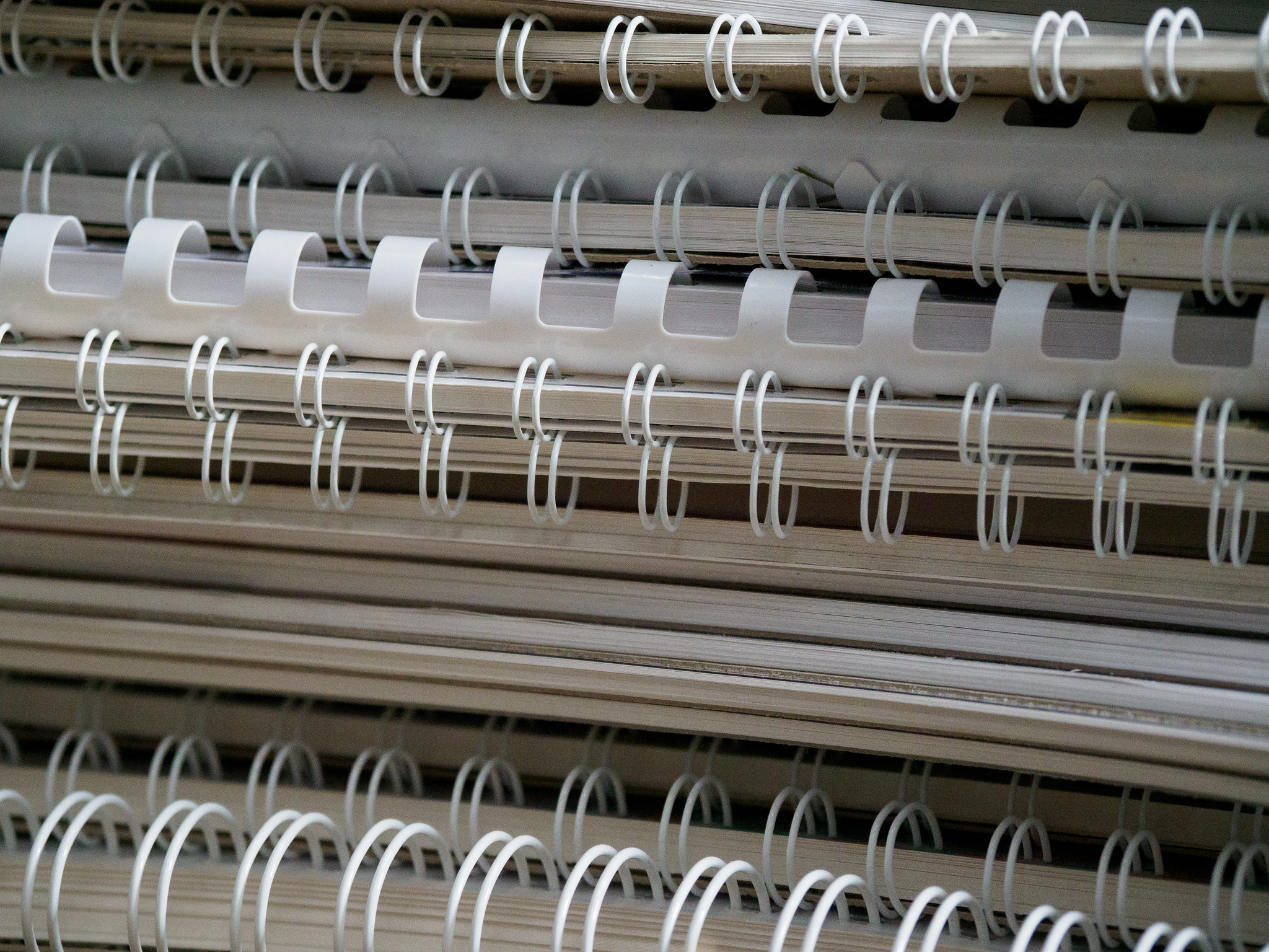 A stack of various white spiral-bound book spines.
