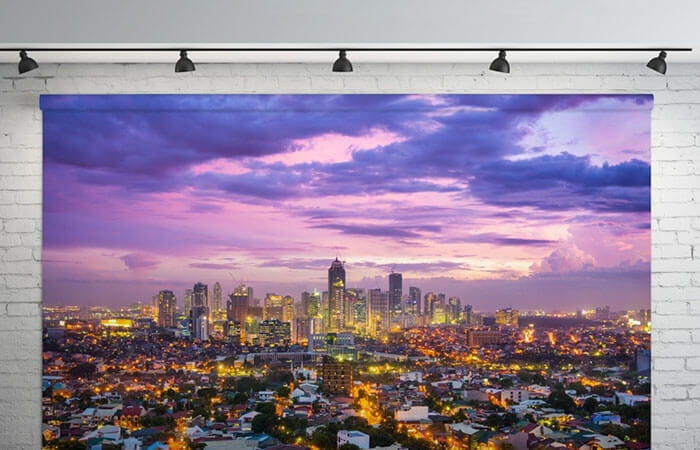 Backdrop of a cityscape at sunset hanging from a brick wall