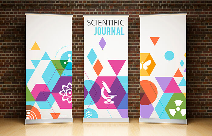 Three colorful pull-up banners against a brick wall