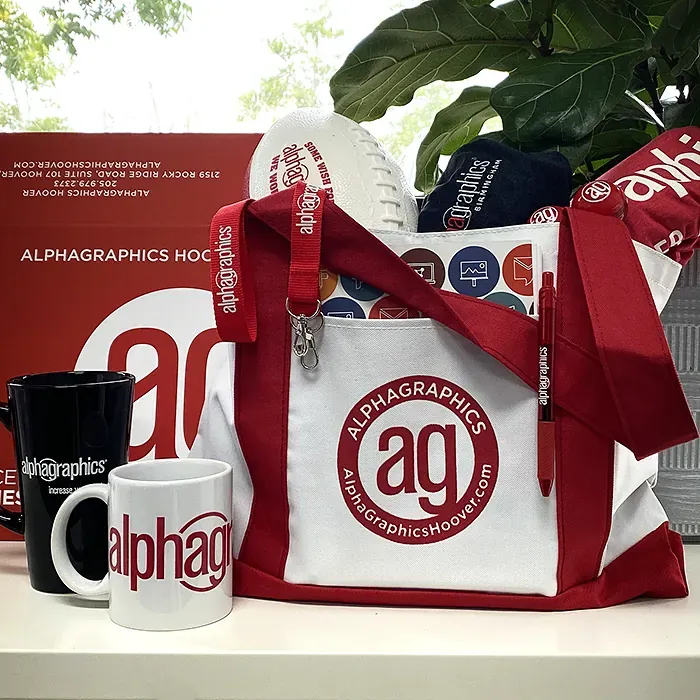 AlphaGraphics Hoover branded tote bag with mugs, lanyard, pen, football and shipping box