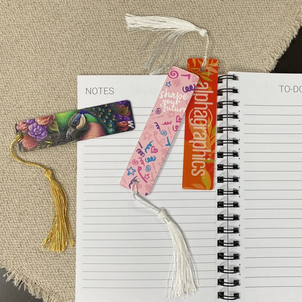 Custom printed bookmarks with tassels on a notebook