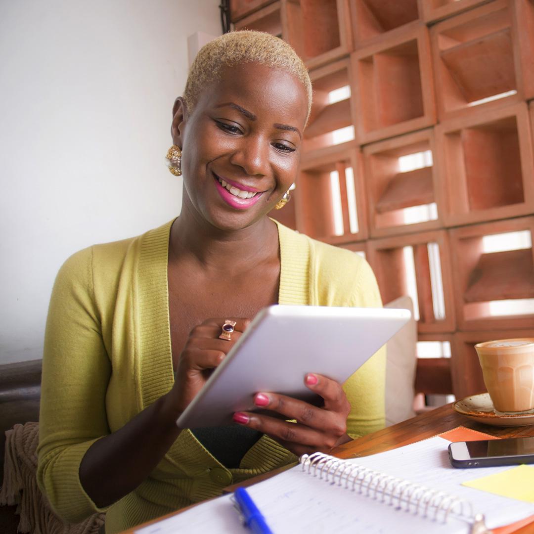 A smiling business owner looking at her tablet