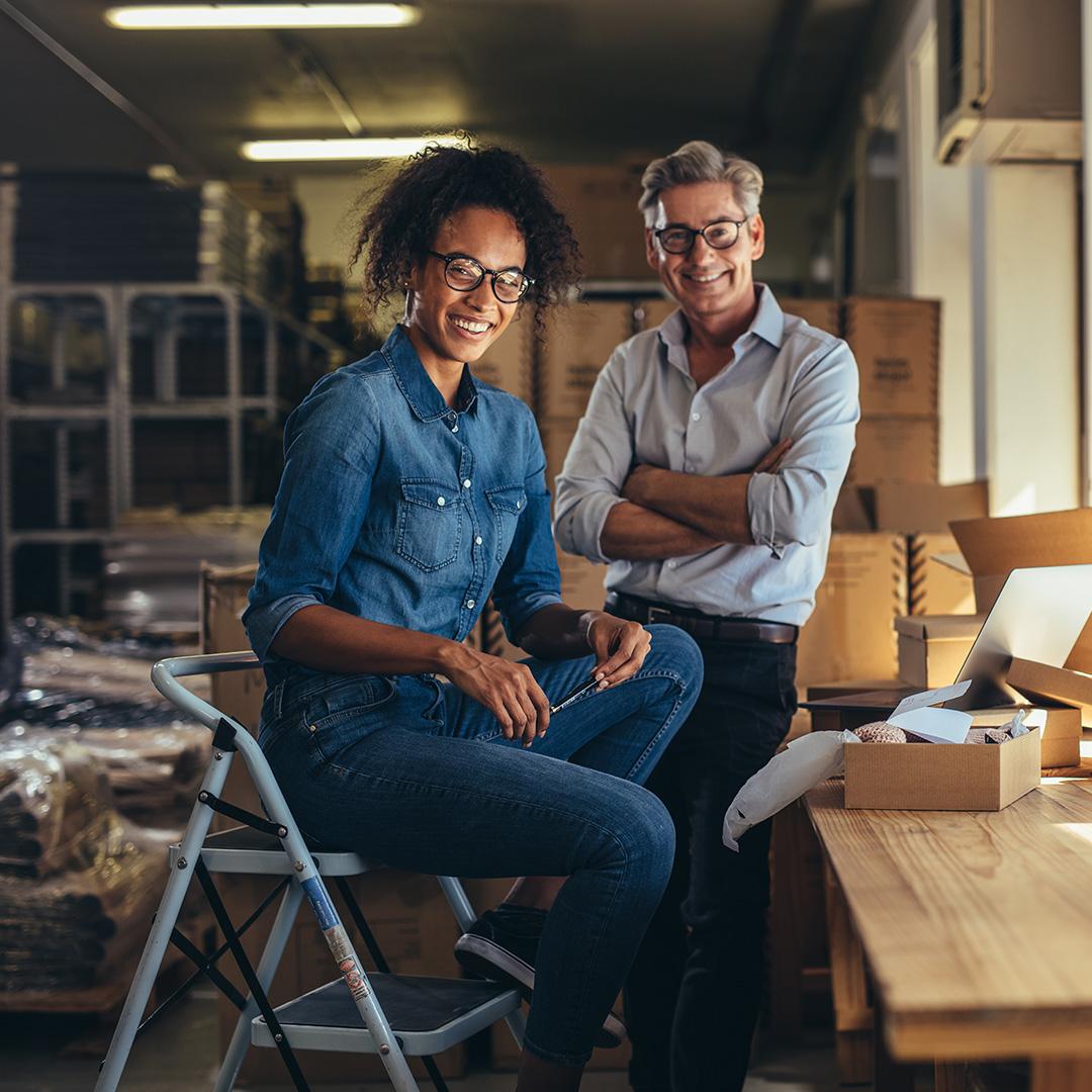 Two happy business owners in their warehouse