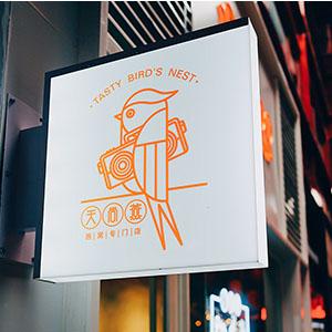 An orange and white restaurant sign on a building's exterior