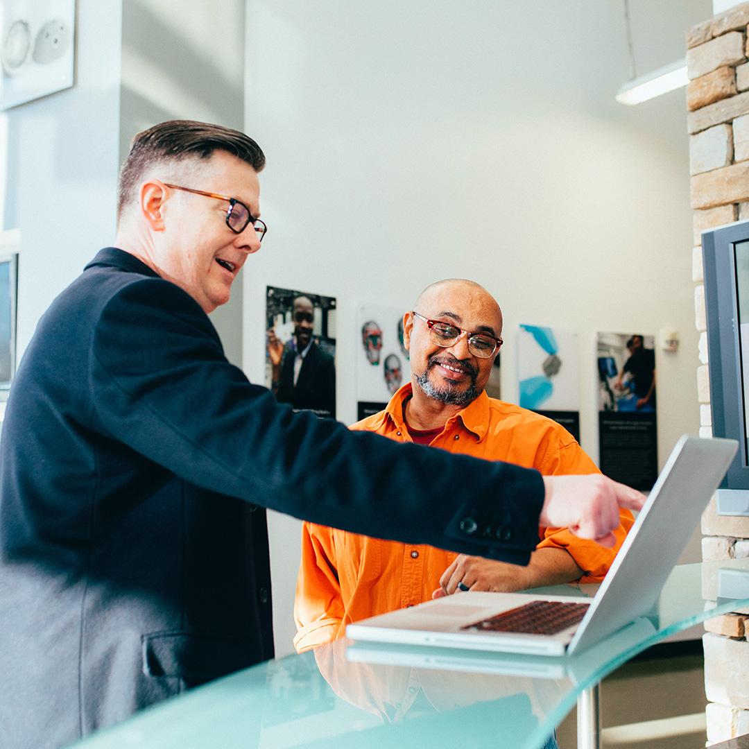 A customer and manager looking at a computer together