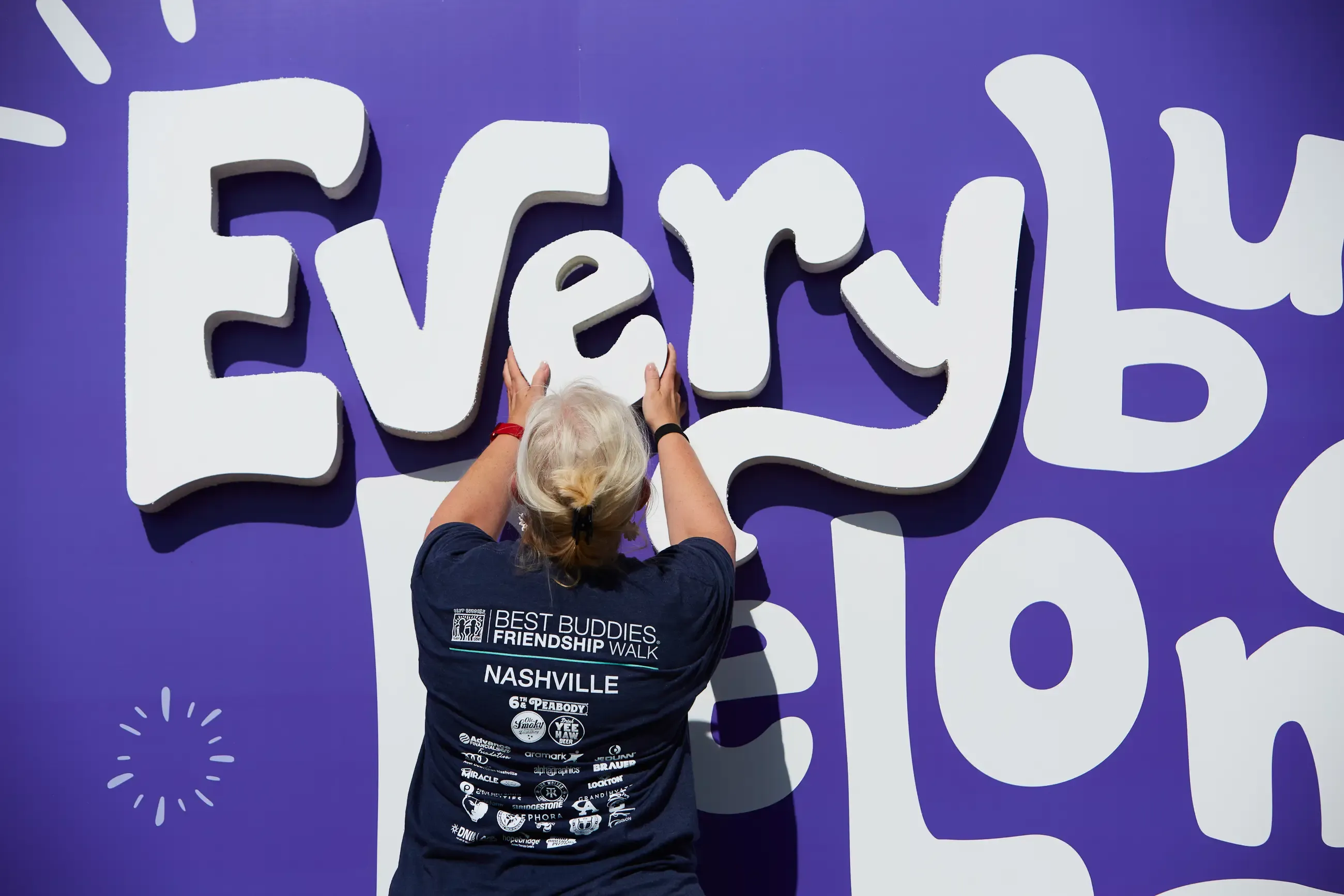 A woman hanging up a custom sign