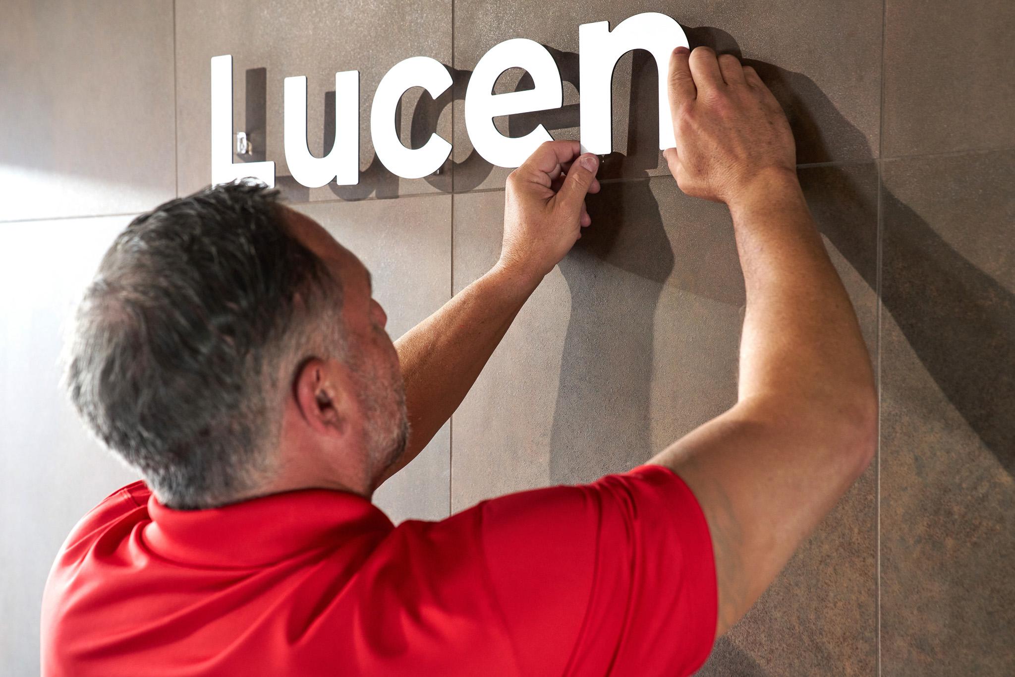 A man hanging a custom sign