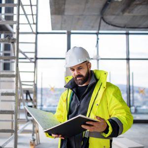 An engineer holding a blueprint booklet