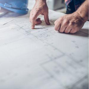 Closeup of a hand pointing to a blueprint