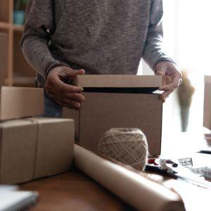 Person carefully packing a box for shipment