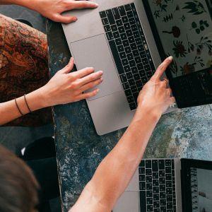 Three people pointing at a computer screen
