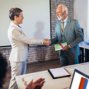 A businessman shaking hands after getting an award
