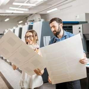 A client and printing professional looking over two prints