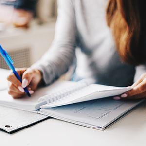 A woman writing in a notebook in her office