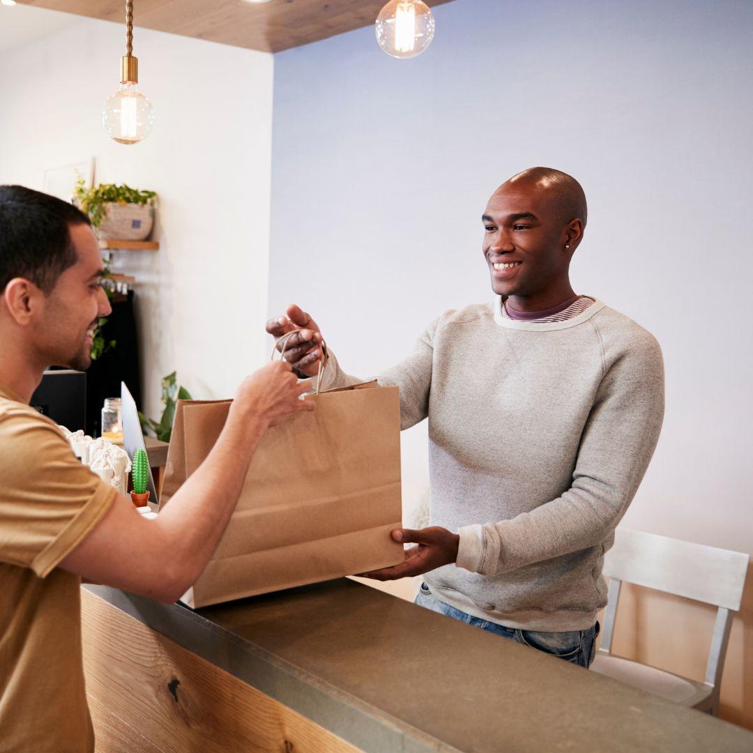 A young man helping complete a transaction at a small business
