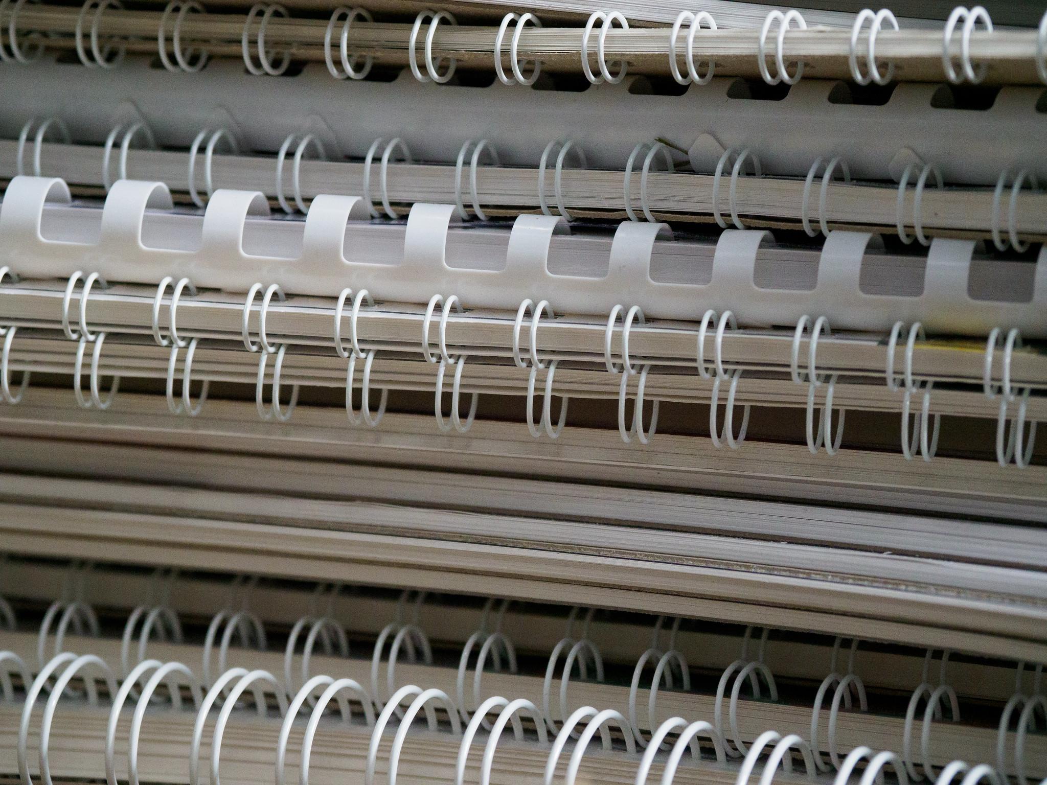 A stack of various white spiral-bound book spines.