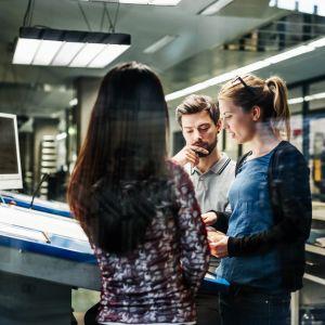 Printing professionals working together at a console