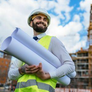 A satisfied engineer with blueprints in his hands
