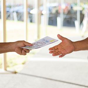 A person handing a brochure to another person