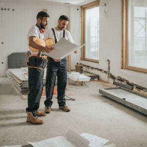 Contractors in a room looking at a blueprint