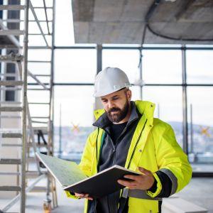 An engineer holding a blueprint booklet