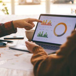 Two small business owners looking at graphs on their computer