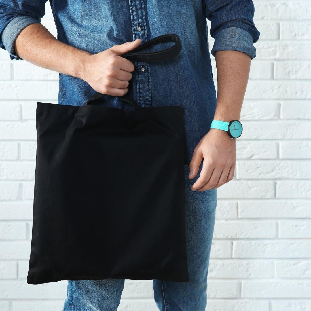 man holding unbranded promotional tote bag
