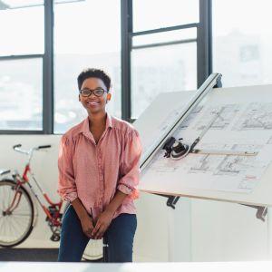 A smiling young architect at her desk