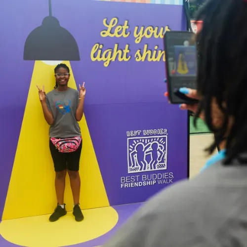 Woman stands in immersive signage with spotlight graphic that says
