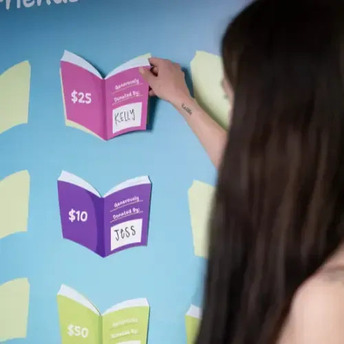 A woman places on a sign a book graphic saying