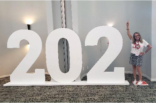 Large signs display the numbers 202 and at the end, a woman poses with her arm up as the 1, making 2021