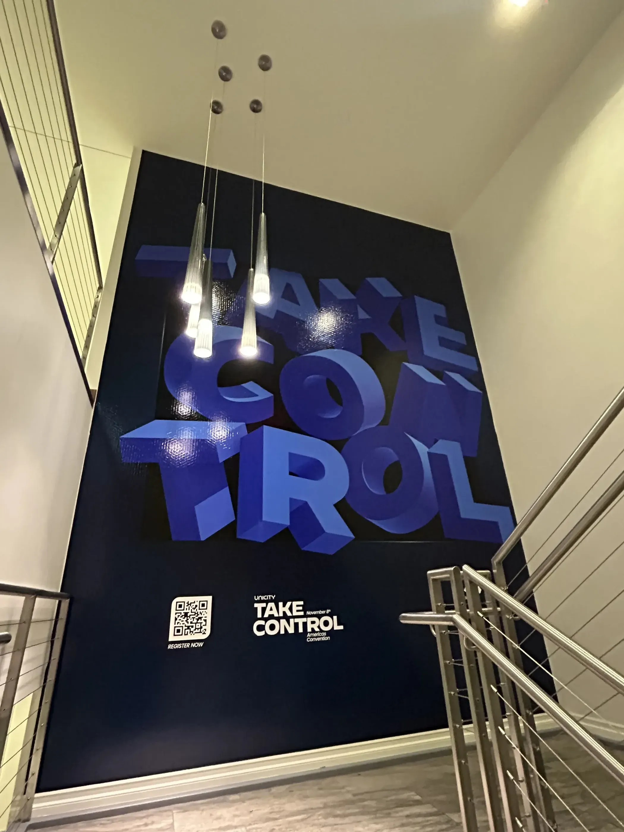 Wall graphic with bold “Take Control” lettering at a stairwell.