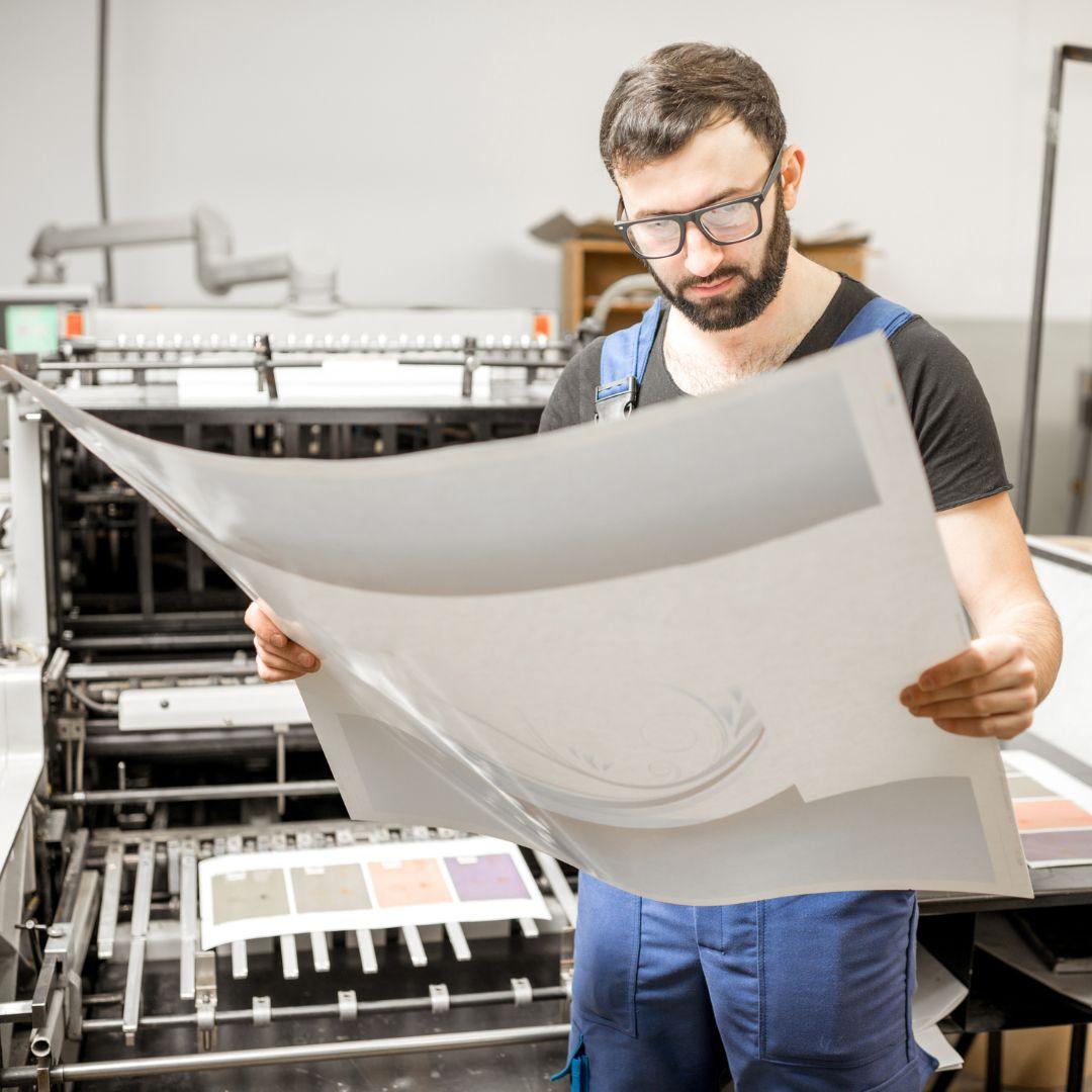 A printing professional looking at a large format print