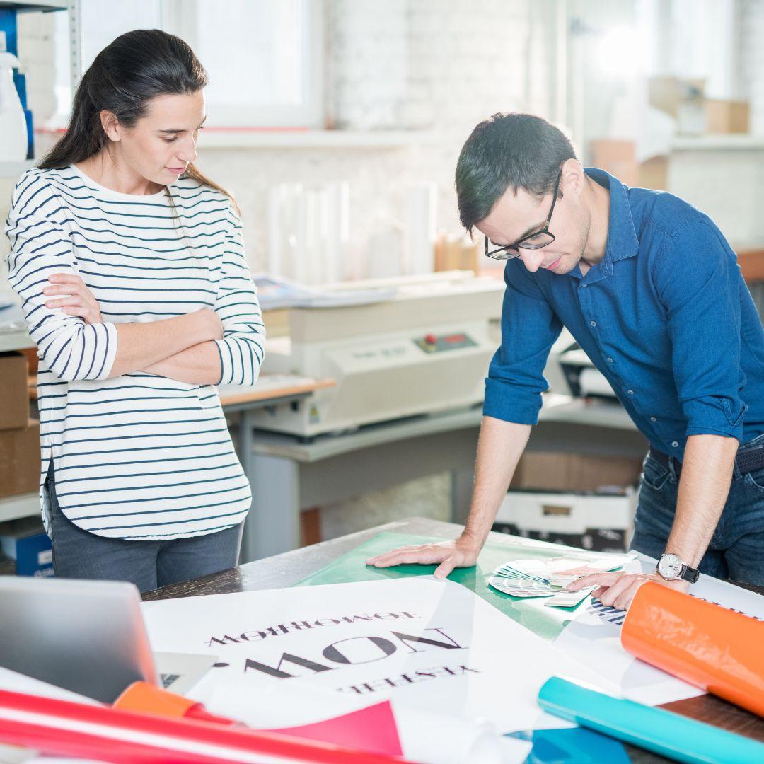 A printing professional and client looking at colors and designs for a project